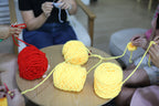 crocheting with yellow and red yarn to make a plushie