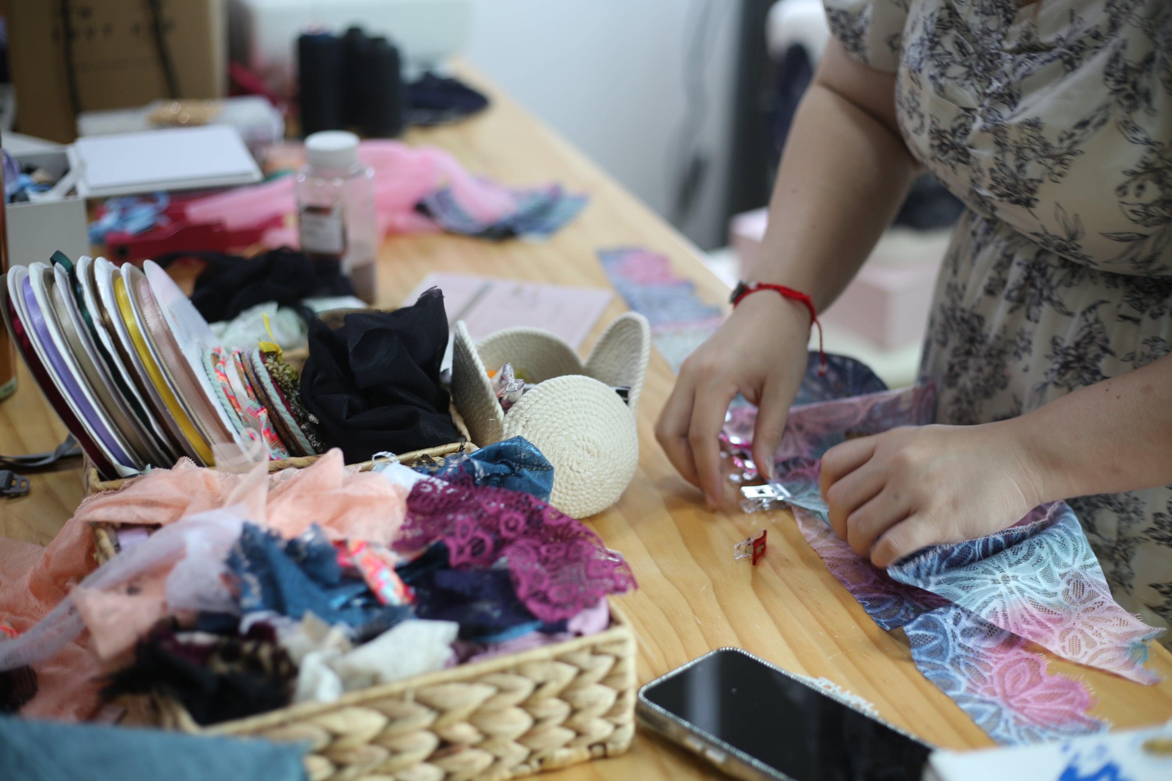 Adjusting and fixing velvet-backed bra straps onto a custom bralette to ensure a perfect fit and elegant design.
