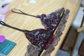 A creator carefully sewing a lace bralette cup using a professional zigzag stitch for stretch and durability.